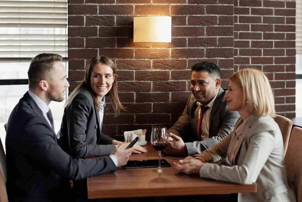 Deux hommes et deux femmes discutent ensemble à table